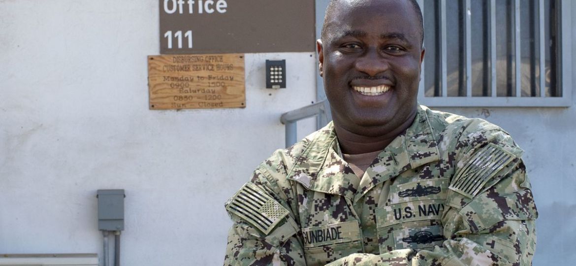 Nigerian Immigrant Lt. Victor Agunbiade in milatary uniform smiling and crossing his arms