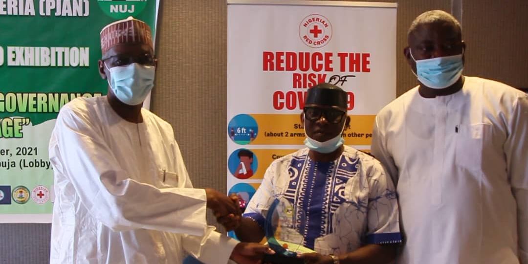 (Middle) Mr. Gabriel Odu, NIDCOM Media, receives Award of Excellence on behalf of Hon. Abike Dabiri-Erewa, Chairman/ CEO, (NIDCOM) at PJAN PHOTO EXHIBITION in Abuja. He is flanked by (L) Mohammed Borno, Chief of staff to FCT Minister and (R) Mr. Abayomi Fayese, PJAN Chairman.