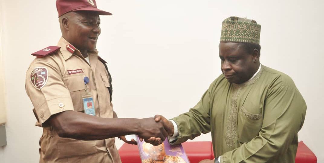 Dr. Sule Yakubu Bassi, the Secretary, NiDCOM (right), presenting a copy of the Diaspora Quarterly magazine to Assistant Corps Commandant (ACC) Owoechukwu Chukwuna (left) during a courtesy visit to NiDCOM by the FRSC team.