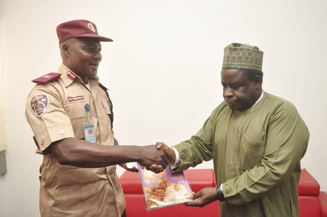 Dr. Sule Yakubu Bassi, the Secretary, NiDCOM (right), presenting a copy of the Diaspora Quarterly magazine to Assistant Corps Commandant (ACC) Owoechukwu Chukwuna (left) during a courtesy visit to NiDCOM by the FRSC team.