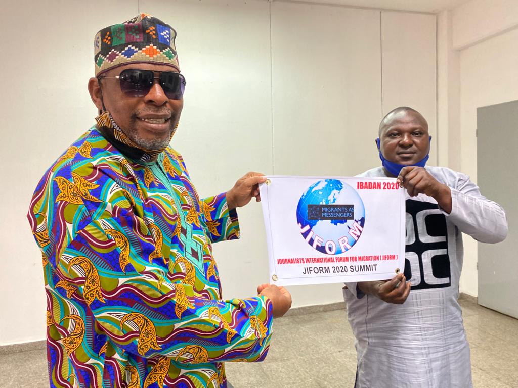 L-R: Mr. Abdur-Rahman Balogun, Head of Media, NiDCOM, representing Hon. Abike Dabiri-Erewa, the Chairman/CEO, NiDCOM, receives the Event Insignia, from Mr. Ajibola Abayomi, President, Journalists' International Forum (JIFORM), ahead of the Forum's Second International Migration Summit, on Thursday in Abuja.