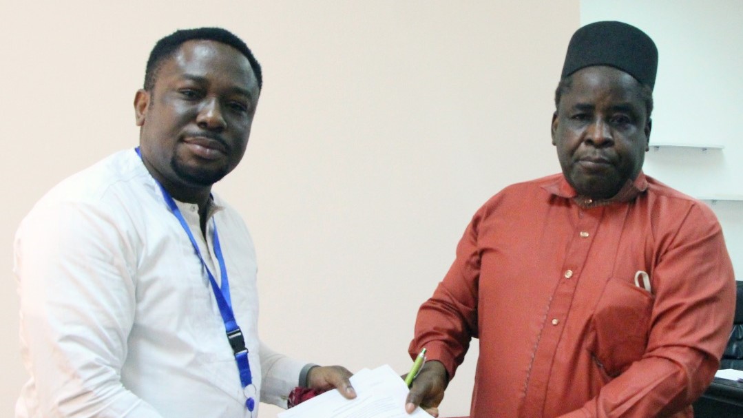 L-R Mr Emeka Anene of IOM and Engr Dr Sule Yakubu Bassi, Secretary of NIDCOM exchanging the signed document for the delivery of the computer at the NIDCOM headquarters, Abuja